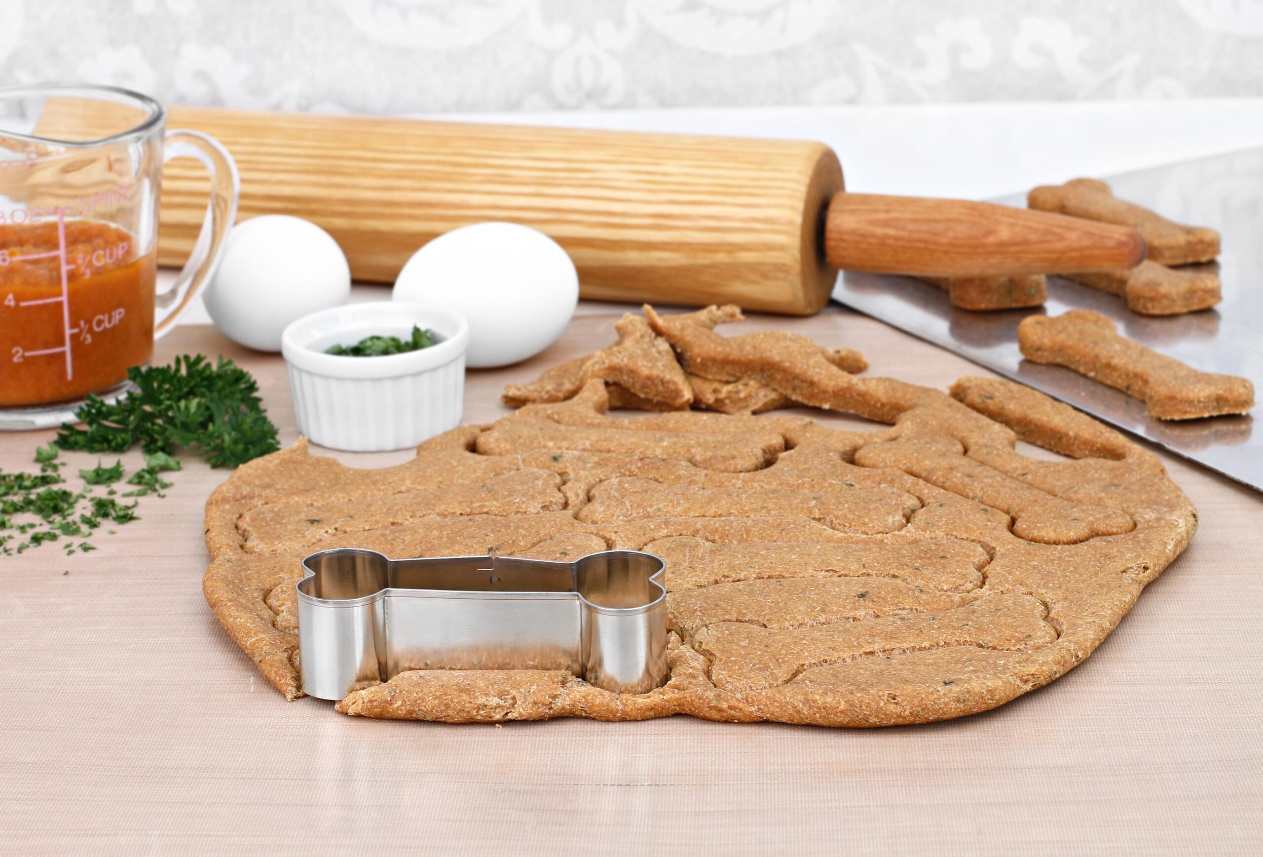 Making homemade pumpkin dog biscuits on a kitchen counter